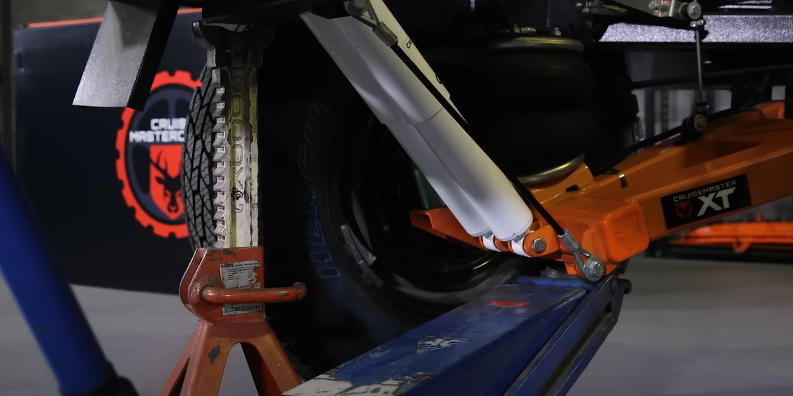 Jacking trailer arm to adjust brake shoes